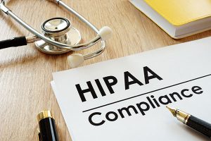 HIPAA合规应用和听诊器在桌子上。
